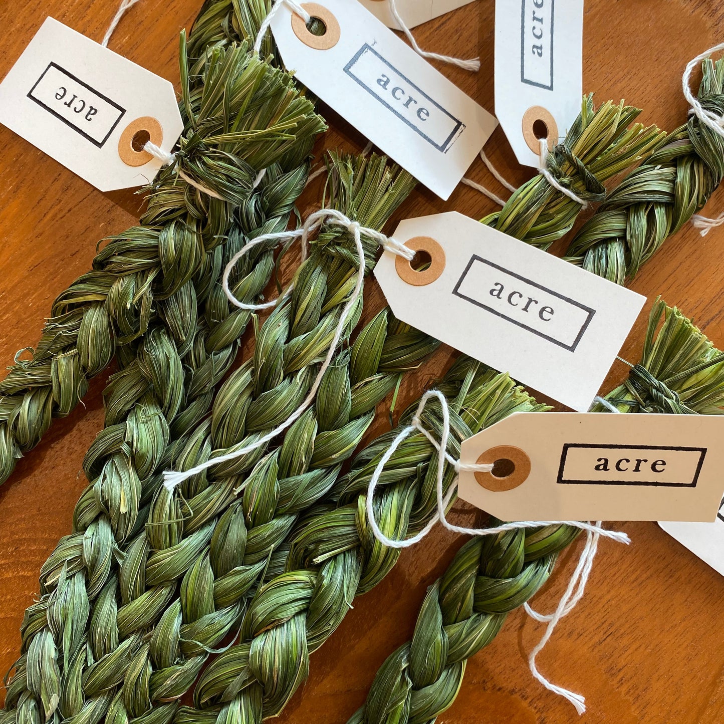 Braided green sweet grass with "Acre" tag on the end